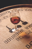 Glass of bourbon sitting on top of a barrel filled with bourbon whiskey  Photo caption credit: Distilled Spirits Council of the United States, Inc.